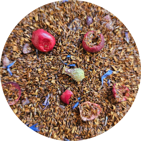 Mezcla de rooibos con trozos de arándano rojo, pétalos de flor azul y vainilla visible.