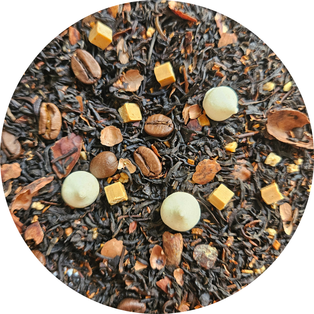 Mezcla de té negro con granos de café, pequeños trozos de caramelo y esferas blancas en primer plano.