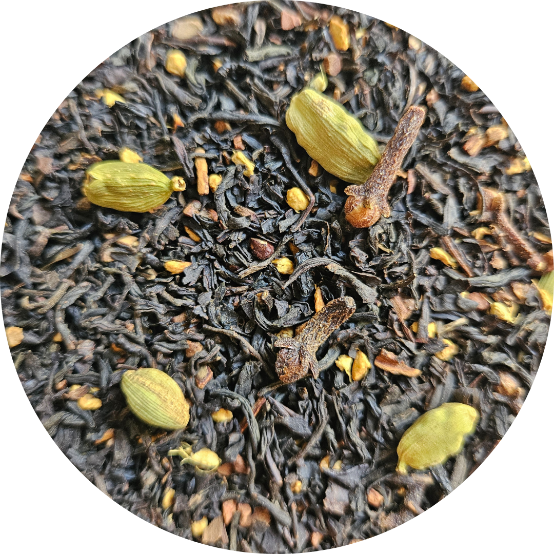 Mezcla de té negro con especias incluyendo cardamomo y clavo, textura suelta y oscura.