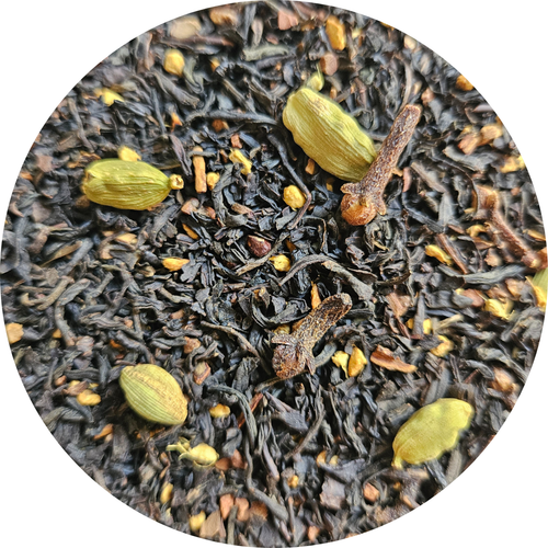 Mezcla de té negro con especias incluyendo cardamomo y clavo, textura suelta y oscura.