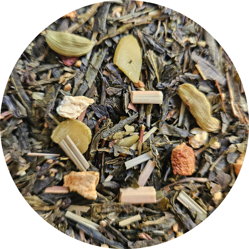 Mezcla de té verde con hojas, trozos de especias y hierbas secas en primer plano circular.