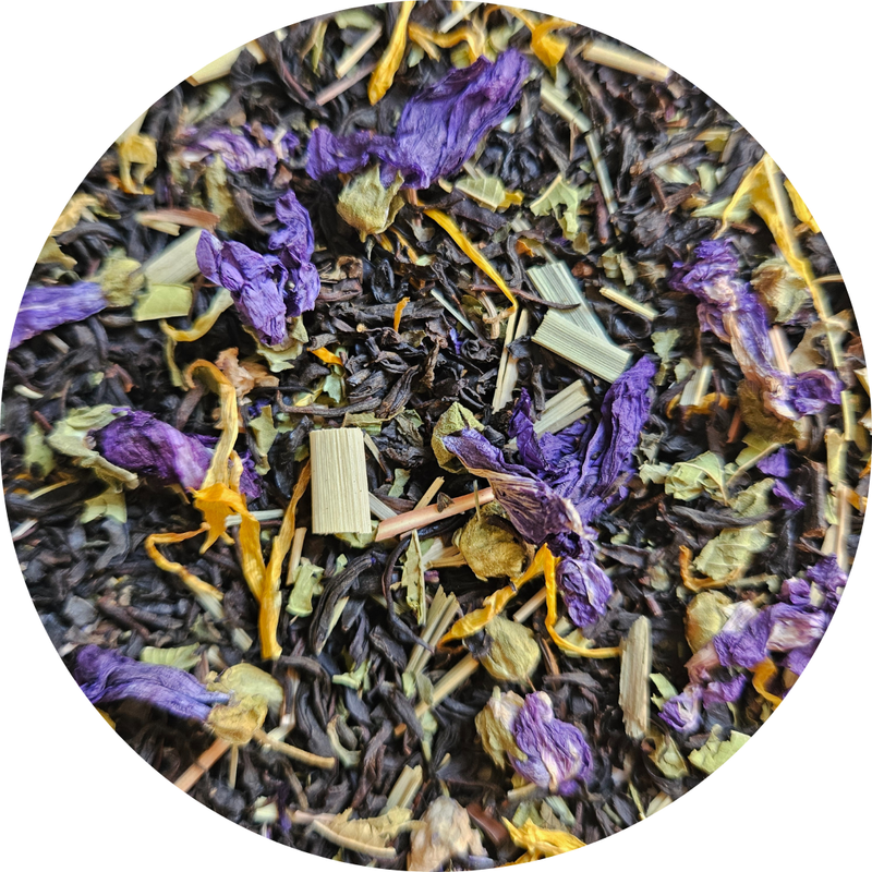 Mezcla de té negro con flores moradas secas y trozos de hierbas amarillas y verdes.