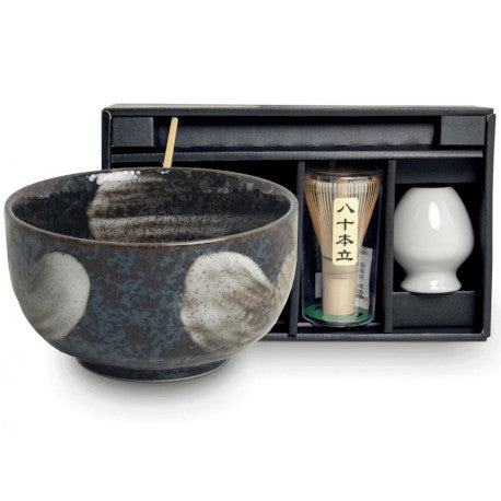 Set para matcha con bowl cerámico negro con detalles blancos, bate de bambú y recipiente blanco en estuche negro.