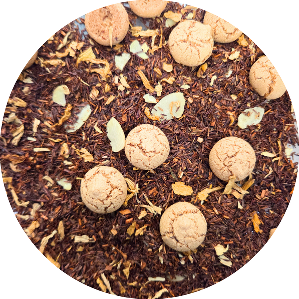 Mezcla de té rooibos con trozos de naranja y galletas pequeñas redondas espolvoreadas.