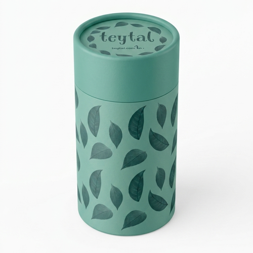 Bote redondo verde con tapa y diseño de hojas oscuras para guardar té.