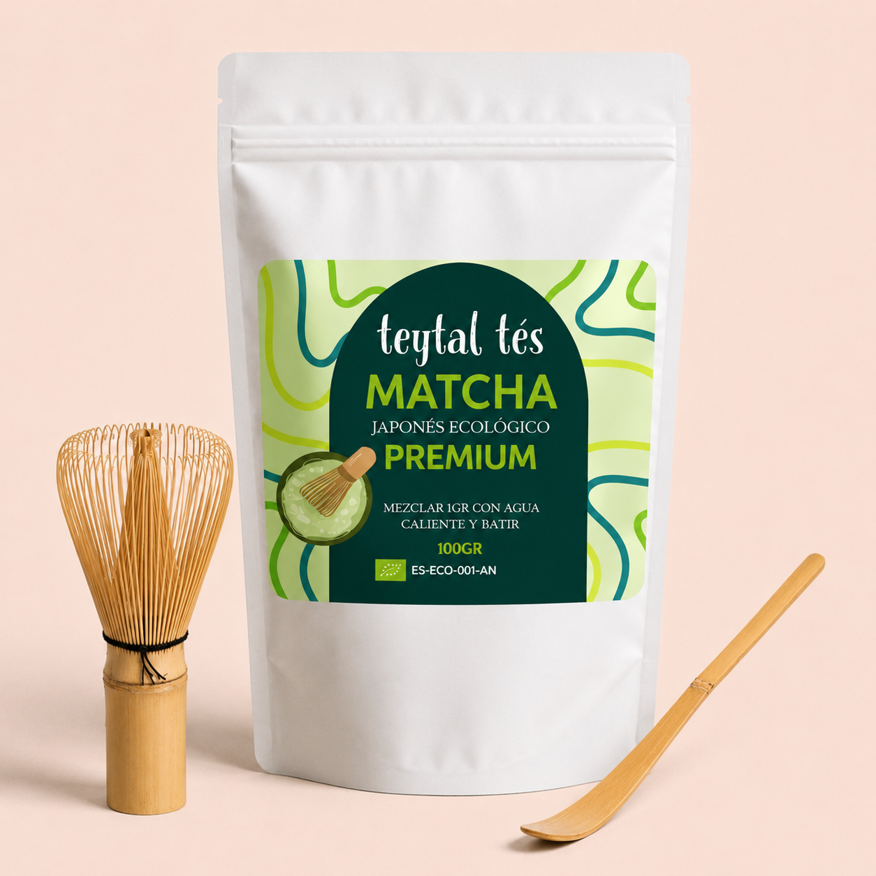 Paquete blanco de matcha premium con etiqueta verde y amarilla, batidor de bambú y cuchara medidora de madera clara.