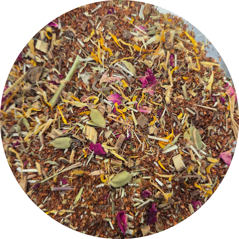 Mezcla suelta de té rooibos con pétalos secos de flores amarillas, rosas y hojas verdes.